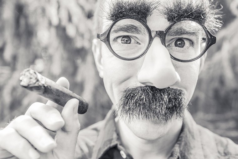 Un homme avec lunette, faux nez et gros sourcils imite Groucho Marx qui brille de tout son talent