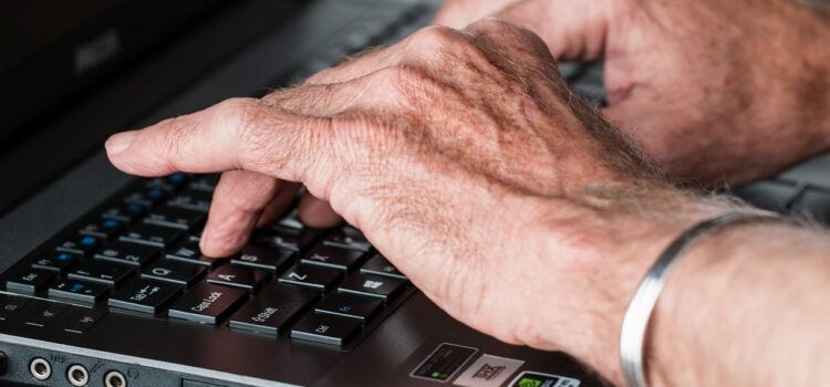 Les mains d'un homme qui tape à l'ordinateur évoquent un gestionnaire en télétravail