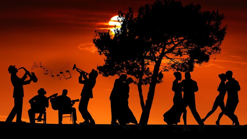Des musiciens et des danseurs de tout âge dansent au soleil couchant.