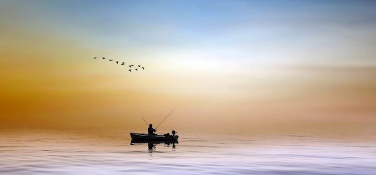 L'écotourisme en forêt c'est aussi y découvrir un lac, comme un trésor : ici un pêcheur, seul dans sa barque à l'aurore, un moment de grand calme et d'attention.