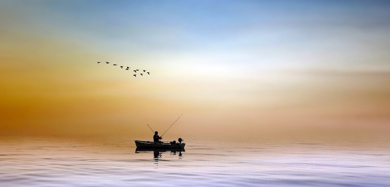 Un pêcheur, seul dans sa barque à l'aurore, un moment de grand calme et d'attention.